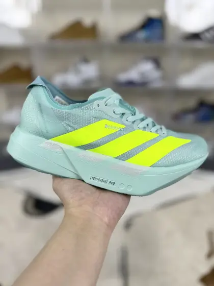 ▪️QD公司级 adidas Adizero Adios Pro 4 百搭舒适减震耐磨 低帮跑步鞋 男女款 苹果绿 ▪️Adidas Adizero Adios Pro 4跑步鞋是一款专为长距离竞速设计的跑鞋.鞋面采用了全新的Lightstrike Pro科技,结合了轻便和透气性,为跑者提供舒适的贴合感.同时,新的Lightlock技术使得鞋面在延展性和舒适性方面有了革命性的提升.鞋面材料轻薄柔软,紧密贴合脚型,鞋舌部分填充少量物质,减轻了系带时的压力.中底采用了Energy Rods(能量杆)技术和Lightstrike Pro发泡材料.Energy Rods技术将碳纤维材质与其他轻量化材料结合,有效提升了能量回馈的效率.而Lightstrike Pro发泡材料则提供了更强的弹性和响应性,尤其适合高速跑步和长时间的耐力赛.相较于前代,Pro4的中底更为柔软和灵活,带来了更好的脚感和推进力.外底采用了Continental橡胶材料,提供了极佳的抓地力,适合各种路况,尤其在湿滑的环境中表现出色.同时,鞋底的起翘点后移到整个鞋底的60%位置,使得鞋子的滚动弧度更加激进,推进感更强.大底上的纹理结构是基于运动员足底压力分布数据分析得来的,进一步提高了鞋子的性能.总而言之,Adidas Adizero Adios Pro 4跑步鞋在舒适性、速度和耐用性方面表现出色,是专业选手和有一定跑步经验的业余高手的理想选择. ▪️ (36 362⁄3 371⁄3 38 382⁄3 391⁄3 40 402⁄3 411⁄3 42 422⁄3 431⁄3 44 442⁄3 451⁄3) ▪️货号:JR1243